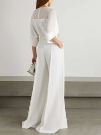 Person wearing a white outfit with a plain background