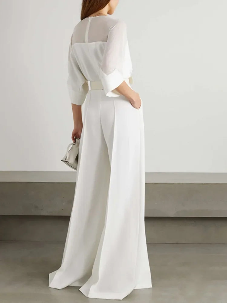 Person wearing a white outfit with a plain background