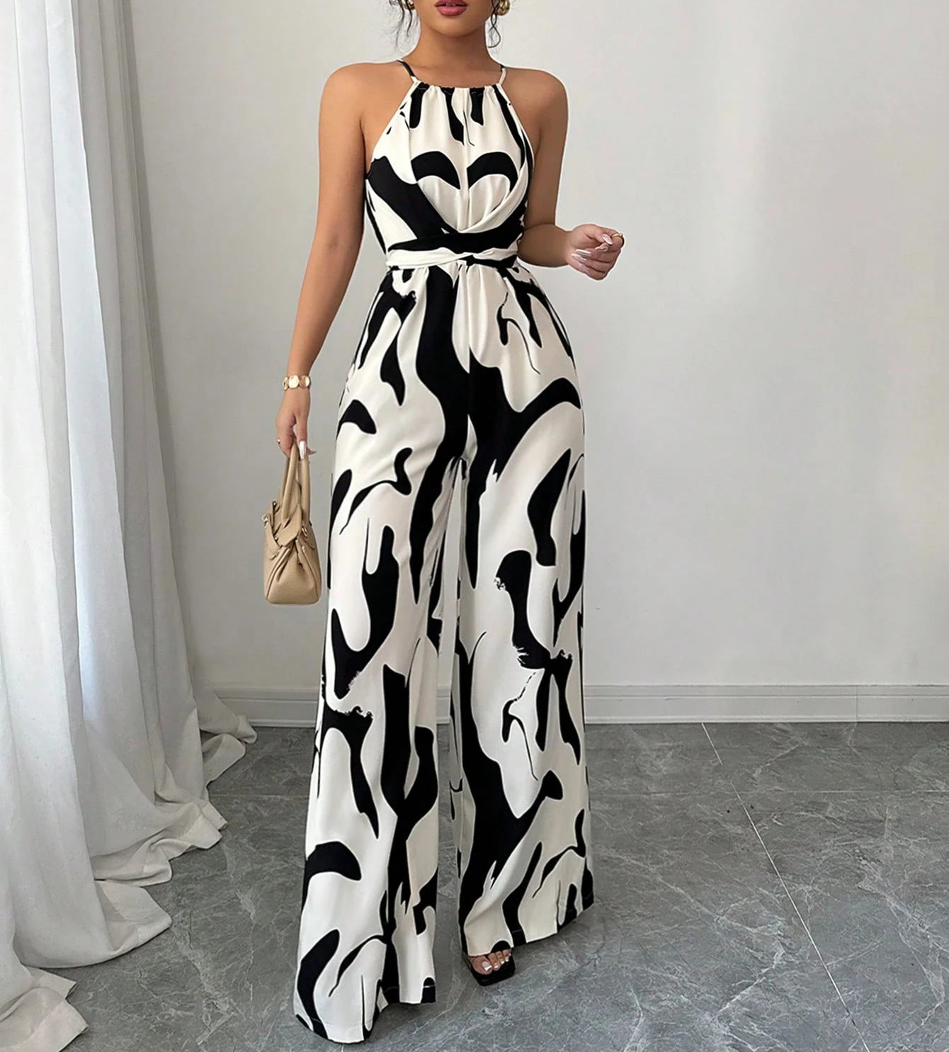Woman wearing a black and white patterned dress in a minimal indoor setting.