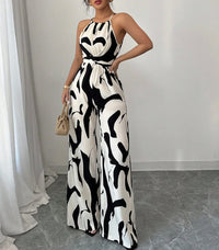 Woman wearing a black and white patterned jumpsuit in an indoor setting.