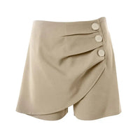 A pair of high-waisted, asymmetric cut women's summer shorts in a light solid color, featuring a button detail on the side.