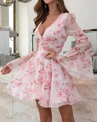 Pink floral dress with long sleeves worn by a person indoors.