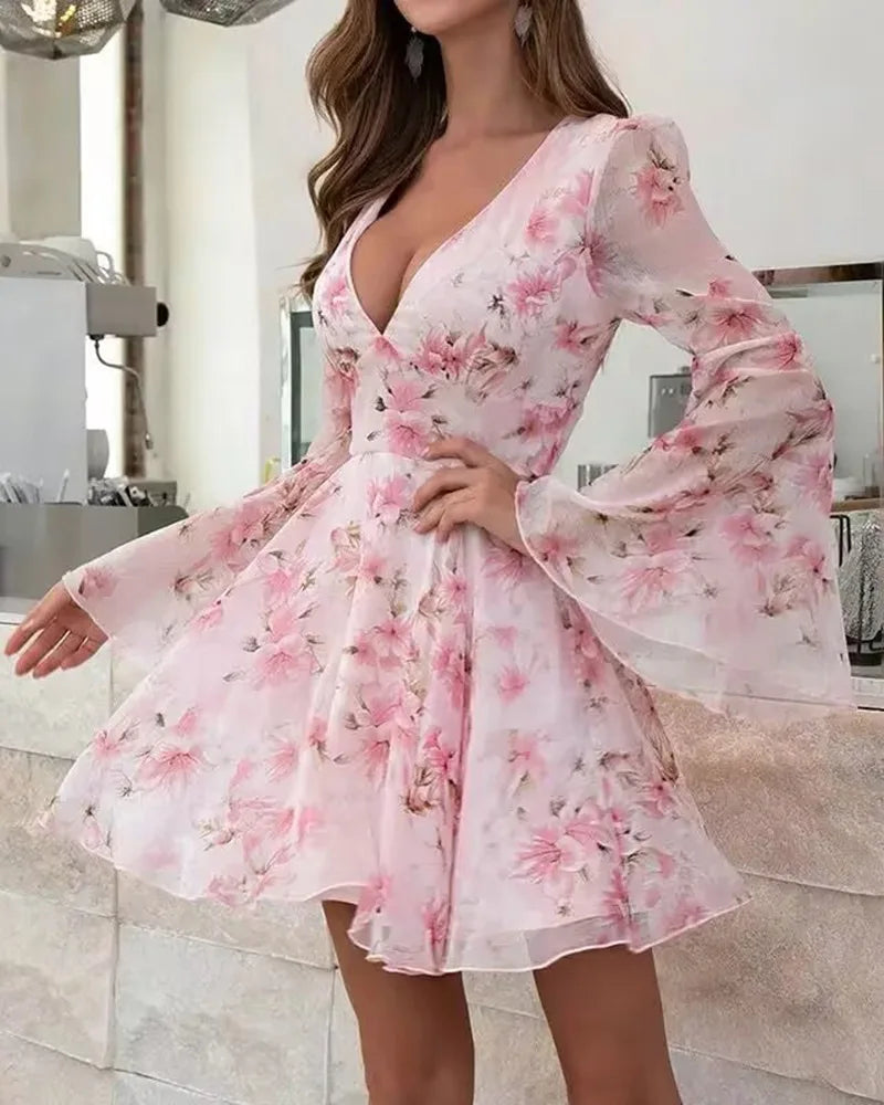 Pink floral dress with long sleeves worn by a person indoors.