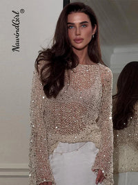 A woman wearing a beige sequins hollow pullover O-neck long sleeve sweater.