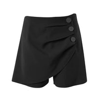 A pair of high-waisted, asymmetric cut women's summer shorts in a light solid color, featuring a button detail on the side.