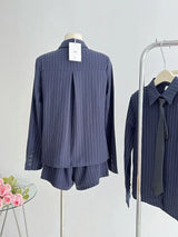 A navy pinstripe two-piece shorts set displayed on a mannequin, including a shirt and shorts.