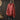 A red vintage turtleneck pullover sweater hanging against a wooden background.